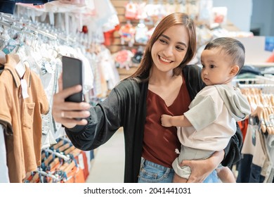 Asian Mother Take Selfie With Her Son While Shopping In The Mall