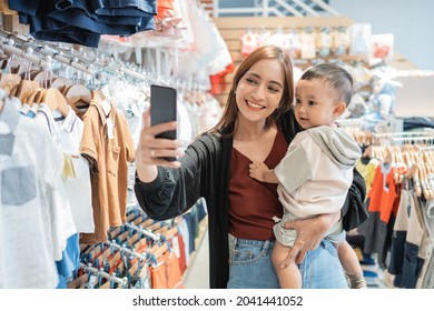 Asian Mother Take Selfie With Her Son While Shopping In The Mall