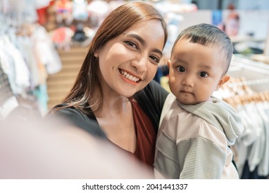 Asian Mother Take Selfie With Her Son While Shopping In The Mall