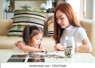 Asian Mother Teach Asian Cute Girl Saving Money Putting Coins Into Piggy Glass Bank, Vintage Tone. Education, Save Money, Asian Family, Investment, Future Investment Or Family Relationship Concept