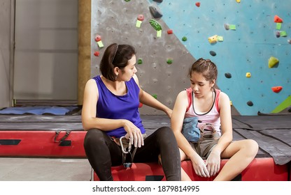 Asian Mother Teaching Her Caucasian Daughter To Climbing Rock For Indoor Sport. Activity, Family And Education Concept.