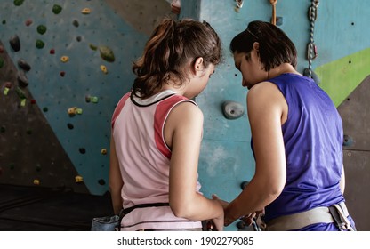 Asian Mother Teaching Her Caucasian Daughter To Climbing Rock For Indoor Sport. Activity, Family And Education Concept.