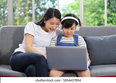 Asian Mother Teaching Her Daughter To Learn From Online Class Using Laptop For Homeschooling And Education Concept