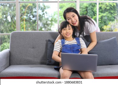 Asian Mother Teaching Her Daughter To Learn From Online Class Using Laptop For Homeschooling And Education Concept