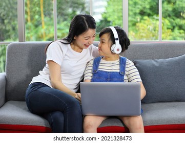 Asian Mother Teaching Her Daughter To Learn From Online Class Using Laptop For Homeschooling And Education Concept