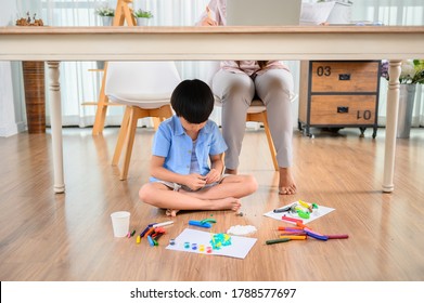 Asian Mother Work Home Together With Son. Mom Online Working And Kid Play Dough Under Table. Woman Lifestyle And Family Activity.