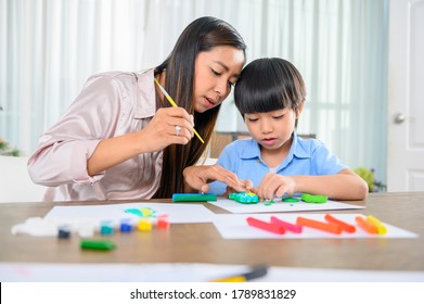 Asian Mother Work Home Together With Son. Mom And Kid Play Dough. Child Creating Plasticine Clay Model. Woman Lifestyle And Family Togetherness Activity. 