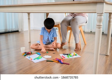 Asian Mother Work Home Together With Son. Mom Online Working And Kid Play Dough Under Table. Woman Lifestyle And Family Activity.