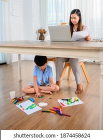 Asian Mother Work Home Together With Son. Mom Online Working And Kid Play Dough Under Table. Woman Lifestyle And Family Activity.