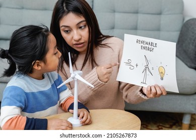 Asian Mother Working With Her Child On Renewable Energy Project For School Science Class At Home - Focus On Mom Right Hand