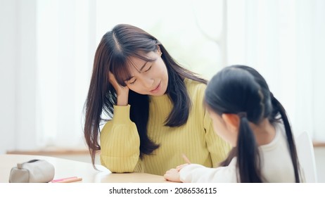 Asian Mother Worrying With Her Daughter. Exhausted With Parenting.