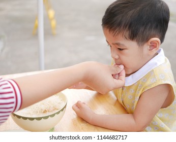 Asian Mother's Hand Introducing A Small Peice Of Crispy Deep-fried Rice Noodle To Her Little Daughter For The First Time - Baby's Development Through Encouraging Them To Try New Foods / Things