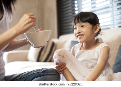 Asian Mum Feeding Child