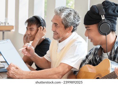 Asian music teacher and schoolboys are consulting and practicing music playing in acoustic guitar lesson afterschool, soft focus, new edited. - Powered by Shutterstock