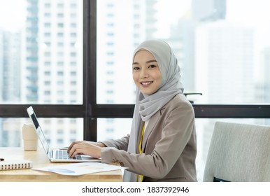 Asian Muslim Business Woman In Hijab Headscarf Working With Computer Laptop In The Modern Office. Business People, Diversity And Office Concept