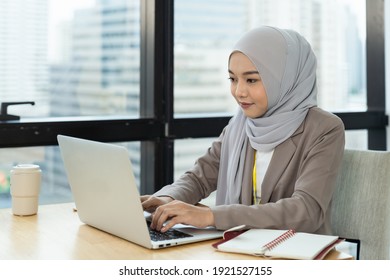 Asian Muslim Business Woman In Hijab Headscarf Working With Computer Laptop In The Modern Office. Business People, Diversity And Office Concept