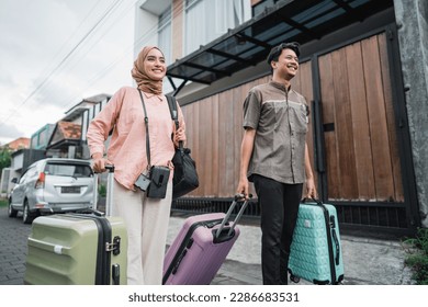 asian muslim couple with suitcase prepare to go. concept of man and woman travelling for eid mubarak celebration - Shutterstock ID 2286683531
