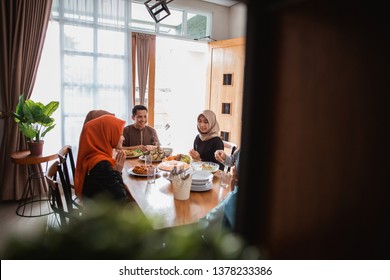 Asian Muslim Family Break Fasting Together In Dining Room