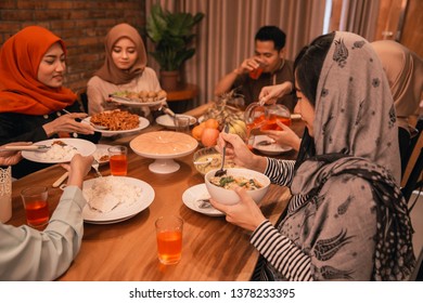 Asian Muslim Family Break Fasting Together In Dining Room