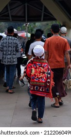 Asian Muslim Kid Using His Prayer Rug To Protect His Back From The Sun