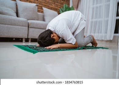 Asian Muslim Kid Wearing Koko Shirt Dress Prostrate Pray On The Prayer Mat