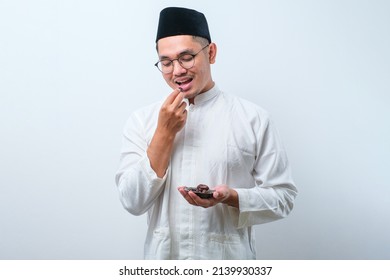 Asian Muslim Man With A Bowl Of Dates Fruit Over White Background Eating For Iftar Breaking Fast