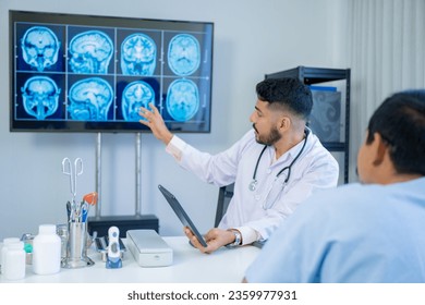 The Asian Muslim man doctor was sitting at the patient's examination table and was examining and talking about the patient with a smiling and worried face. - Shutterstock ID 2359977931