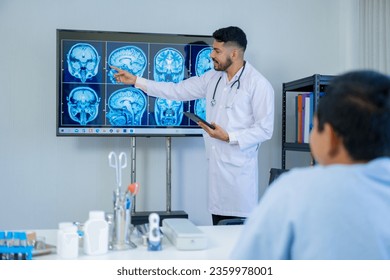 The Asian Muslim man doctor was sitting at the patient's examination table and was examining and talking about the patient with a smiling and worried face. - Shutterstock ID 2359978001