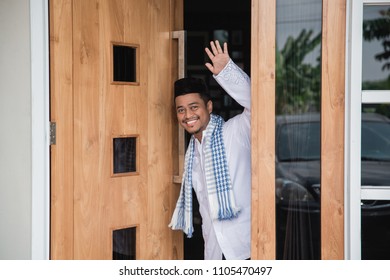 Asian Muslim Man At His Front Door Greeting Guest