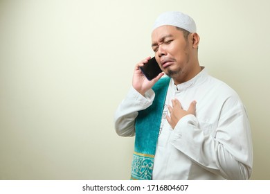 Asian Muslim Man Looks Sad When Receiving News From His Smartphone. The Man Was Sad Because He Could Not Meet His Family At Home