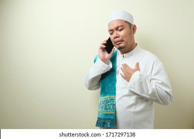 Asian Muslim Man Looks Sad When Receiving News From His Smartphone. The Man Was Sad Because He Could Not Meet His Family At Home