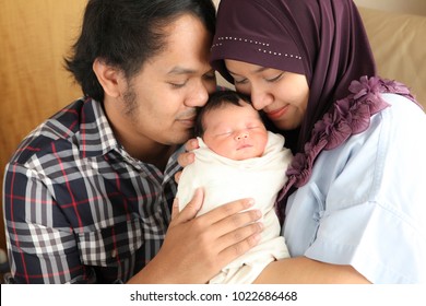 Asian Muslim Mother And Father Holding,hugging Newborn Or Baby With Love. Nursing,care And Love Concept.