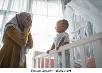 Asian Muslim Mother Play Peek A Boo With Her Son At Home