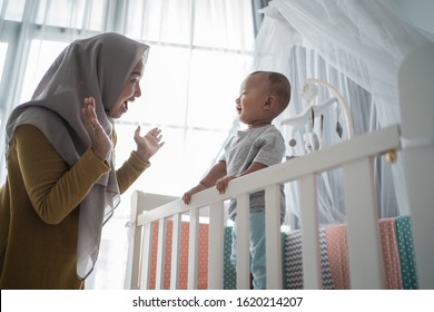 Asian Muslim Mother Play Peek A Boo With Her Son At Home