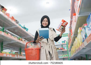 Asian Muslim Woman Buying Some Halal Product At Supermarket