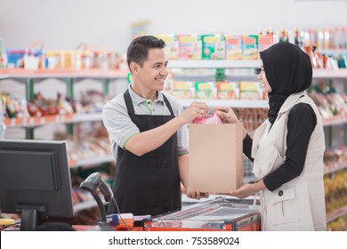 asiatische Muschelfrau kauft ein halales Produkt im Supermarkt