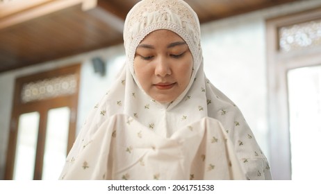 Asian Muslim woman praying hopefully in the mosque