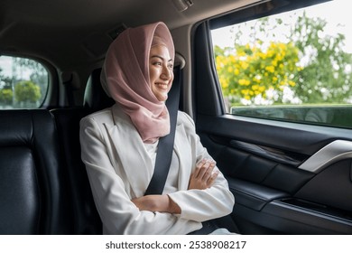 Asian muslim woman traveler sitting in car back seats call taxi service put on safety belt. Female islamic passenger in car traveling to destination. - Powered by Shutterstock