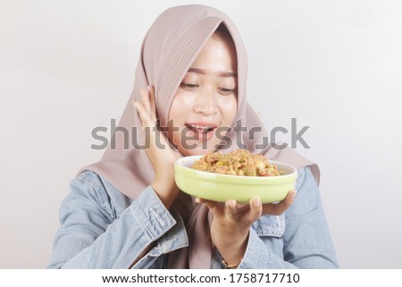 Asian Muslim women bring a plate of salad or rujak ulek