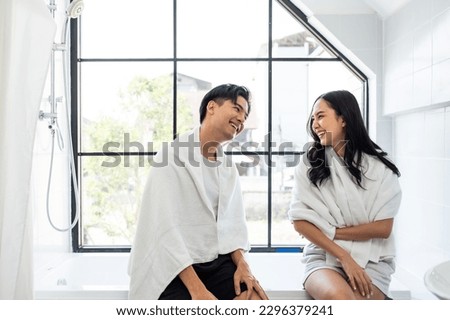 Asian new marriage couple spending time together in bathroom at home. Attractive young man and woman feeling happy and relax, enjoy holiday honeymoon anniversary day then looking each other in house.