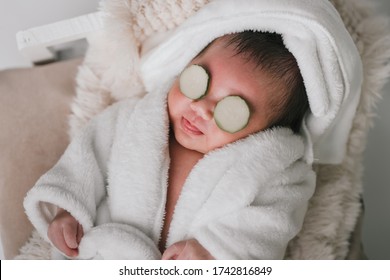 Asian Newborn Baby Boy In White Bathrobe And Eye Cover By Cucmber Props. Shot In The Studio With Isolated White Background. 