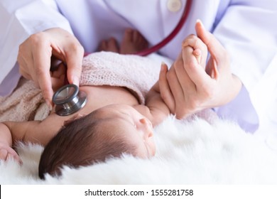 Asian Newborn Baby Get Sick Sleeping During Examine By Pediatrician Doctor Hand Hold Stethoscope, Specialist Monitor Heart Pulse Rate Adorable Infant Crying On Bed In Clinic, Pediatrician With Child