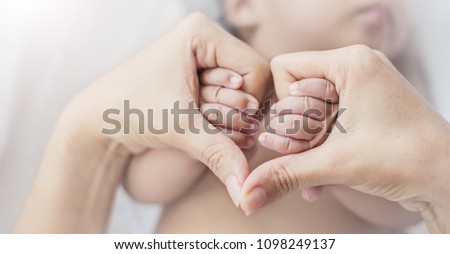 Asian newborn baby holding mother hands in heart shape, Closeup hand of asian newborn baby day. copy space background banner family parents love mother’s day concept banner