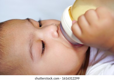 An Asian Newborn Baby Or Little Baby (about 4-6 Months) Drinking Milk From Bottle. The Concept Of Love, Care, Empathy, Lovely, Cute, Adorable And Pretty.