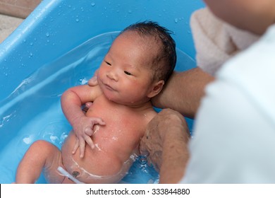 Asian Newborn Baby Is Taking Bath In Blue Tub