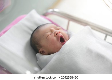 Asian Newborn Baby Yawn In  Bassinet At Delivery Room At Hospital.