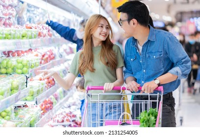 Asian Newlyweds Shopping For Groceries In The Supermarket