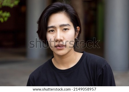 Asian non-binary LGBT person looking at camera