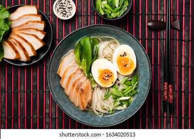 Asian Noodle Soup Ramen With Chicken And Egg Served In Bowl On Bamboo Mat. Top View