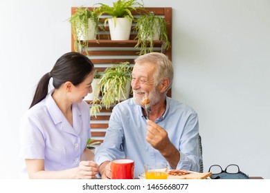 Asian Nurse Enjoy Assist Senior Man Having Breakfast And Happy Together